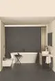 Badezimmer mit freistehender Badewanne, schwarzem Waschbecken mit Holzunterschrank und Ideal Standard Wannenarmatur in Silk Black. Minimalistisches Design mit dunkler Wand und stilvollen Akzenten.